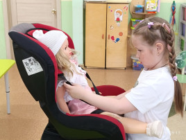 воспитанница сажает и пристёгивает куклу воспитанница сажает и пристёгивает куклу.